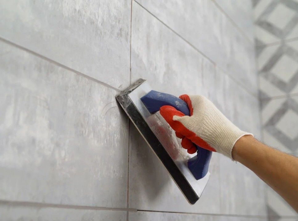 Zest Underfloor Heating Birmingham- fitting grey tiles to a wall in a bathroom