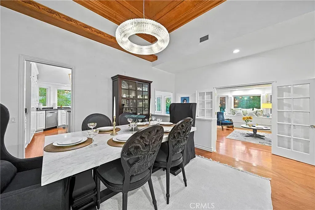 Elegant dining room with chandelier, set table, and open doorways to adjoining rooms | Best Realtor in Santa Clarita, CA
