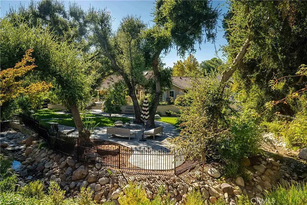 Stone-lined area with wooden posts and a stone wall, surrounded by trees | Homes for Sale in Santa Clarita, CA