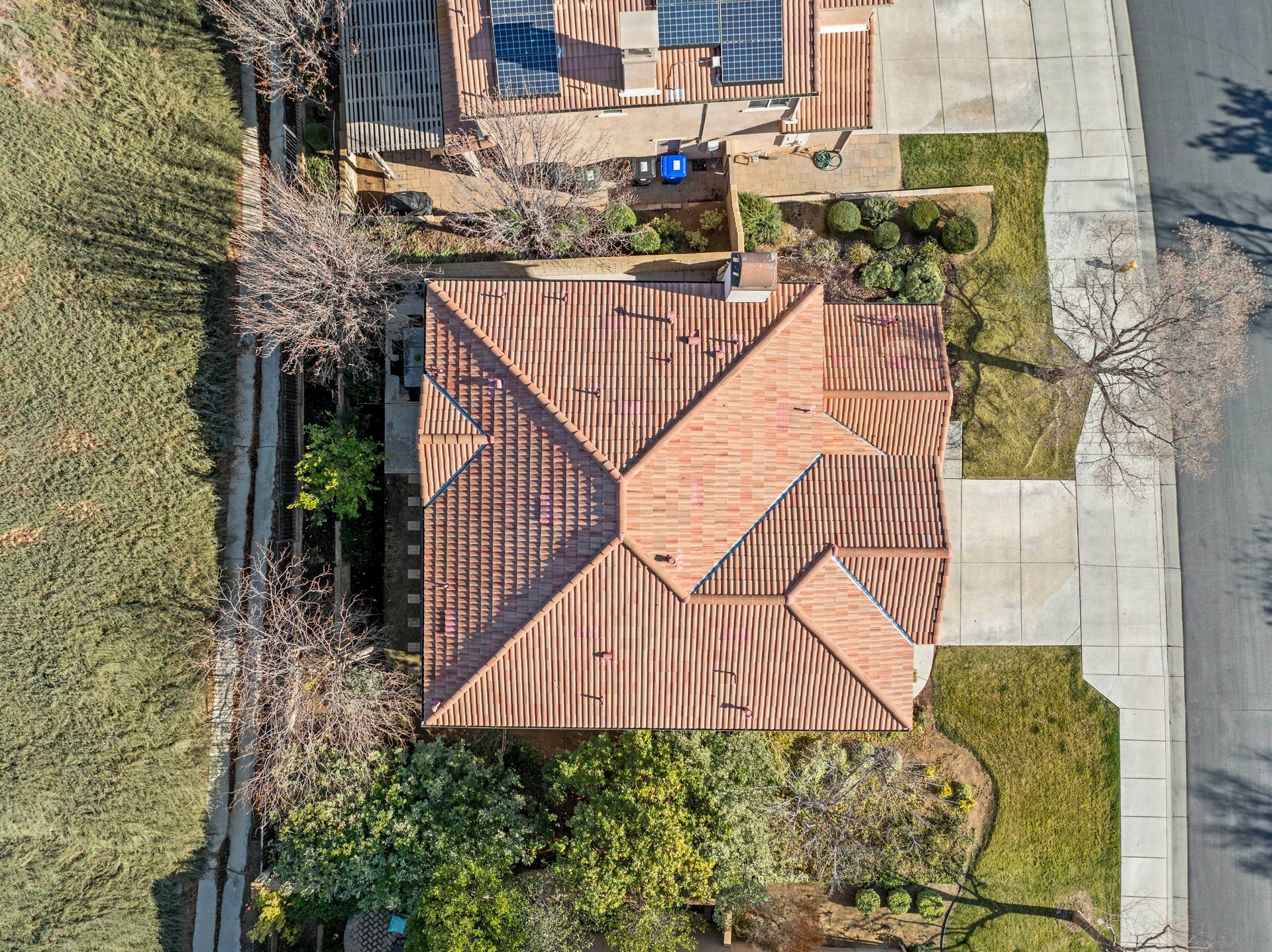 Overhead view of a house with a brown tile roof, next to a street and grassy areas | Sell my home fast in Santa Clarita, CA