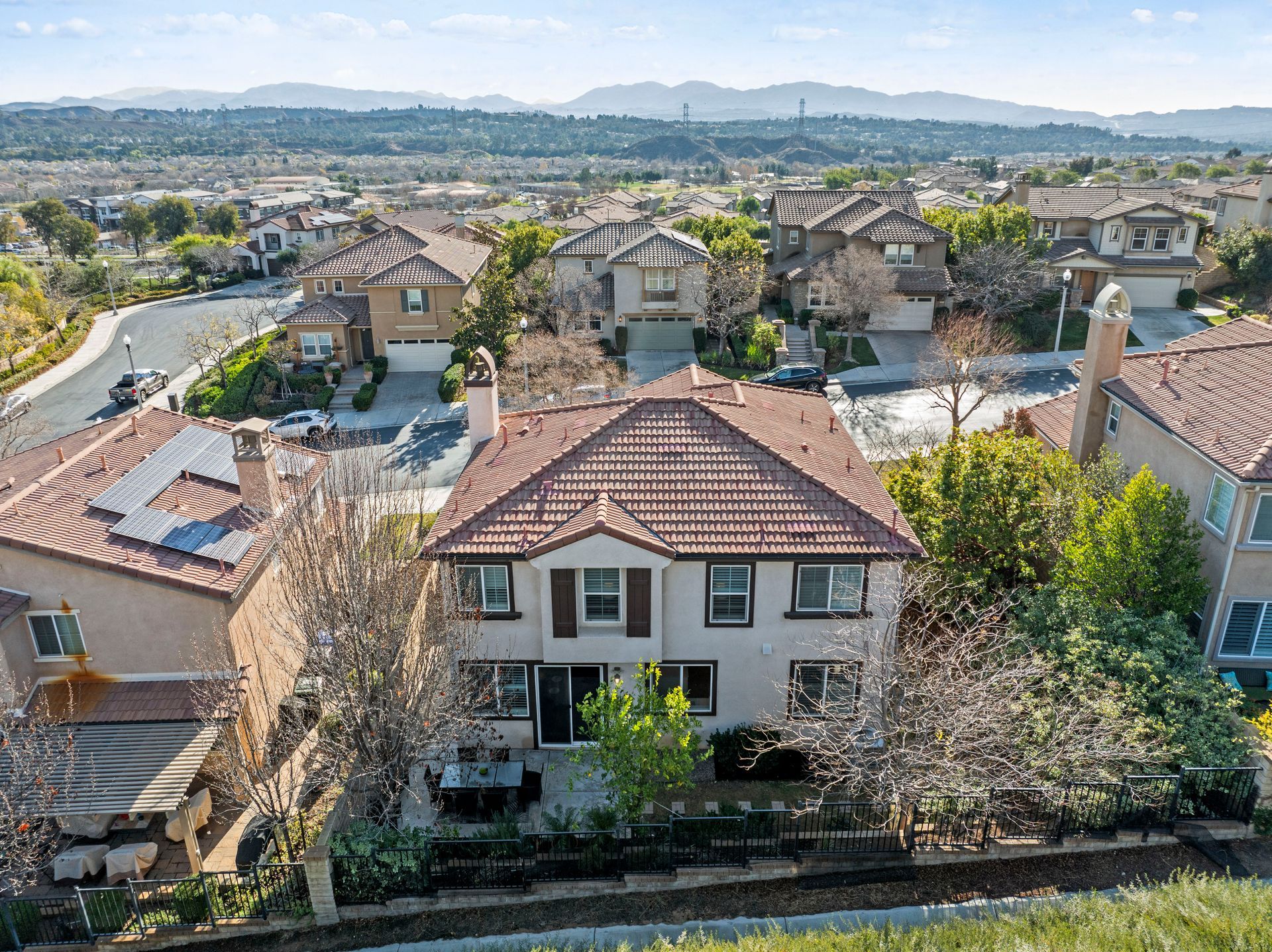 Houses in a suburban neighborhood with terracotta tile roofs, surrounded by trees | homes for sale in Santa Clarita