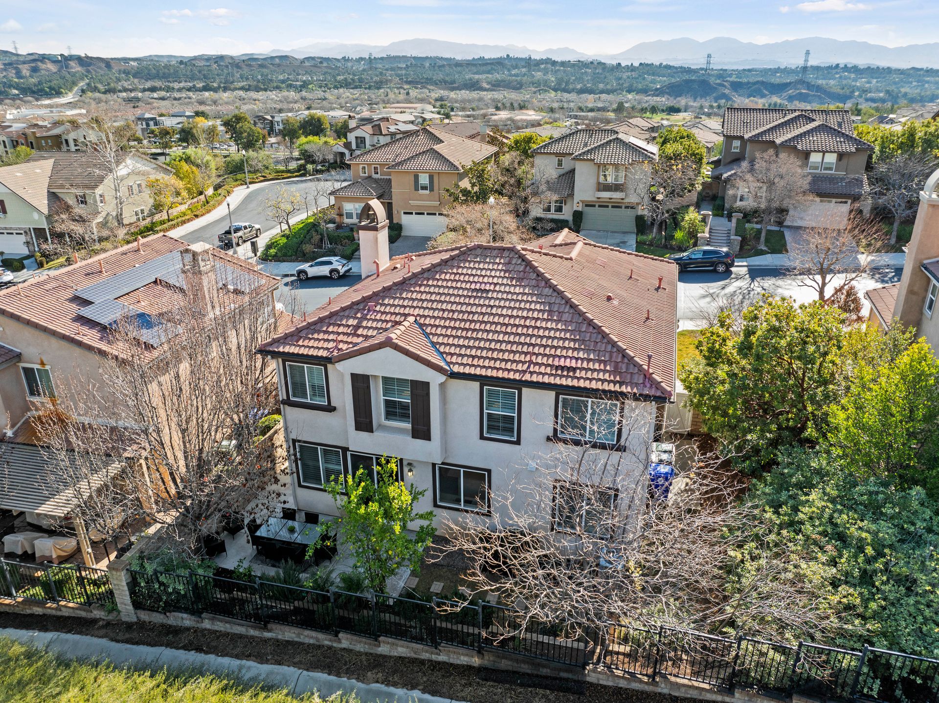 An aerial view of a two-story beige house with a brown tile roof | sell my home fast in Santa Clarita, CA