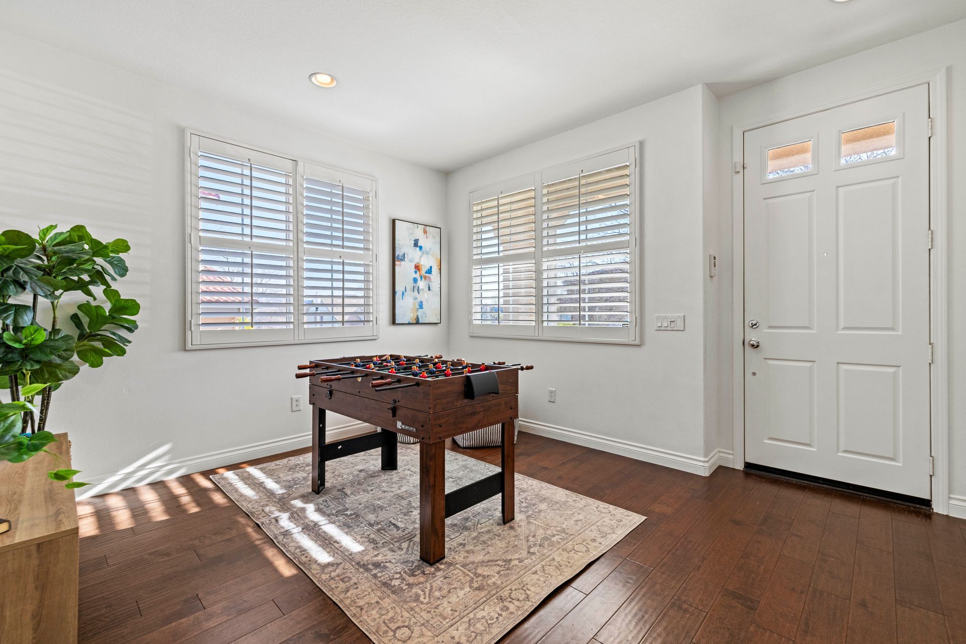 Game room with a foosball table, flat-screen television, wall decor, and indoor plants.