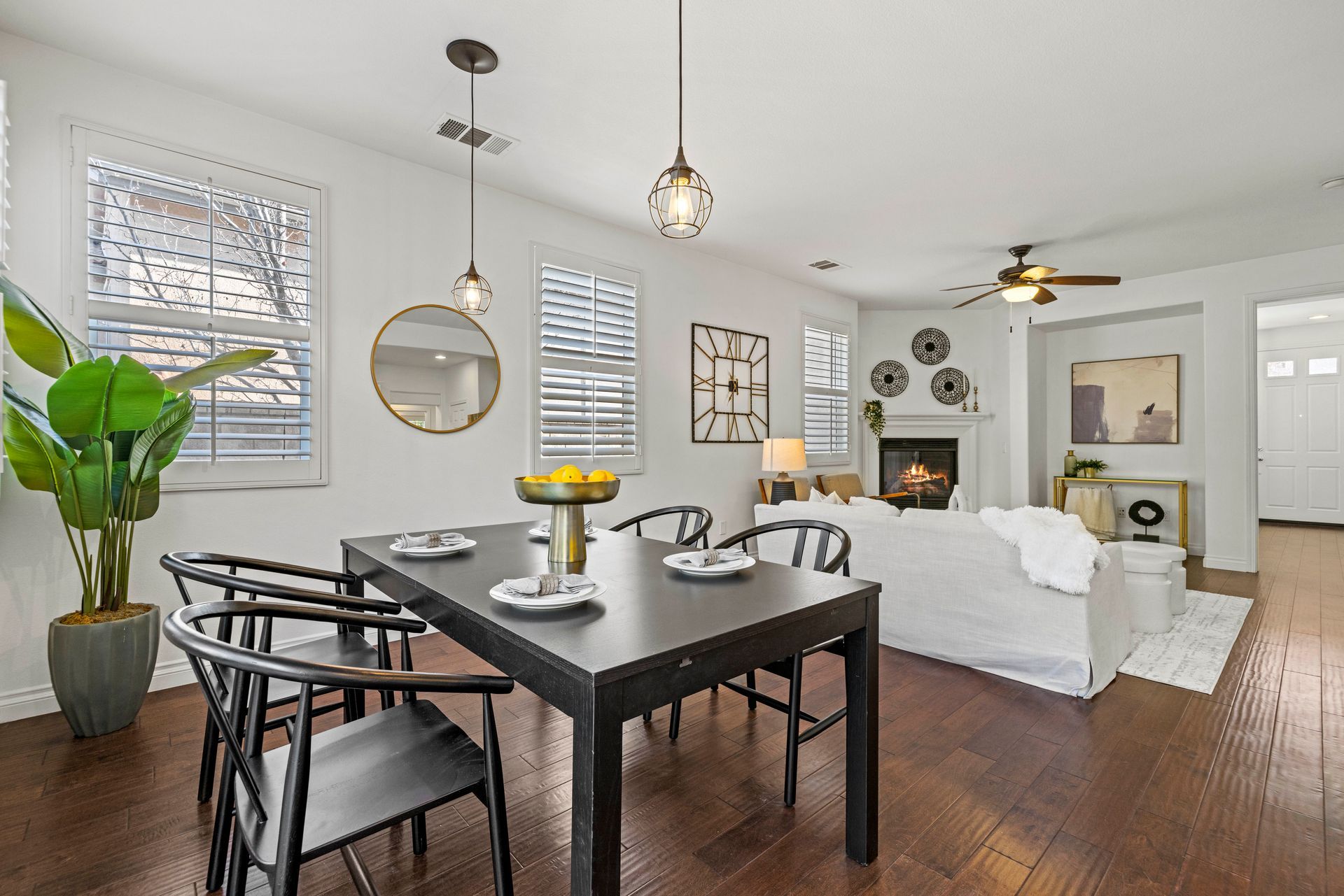 Modern and open dining area that directly connects to a small living room with a fireplace.
