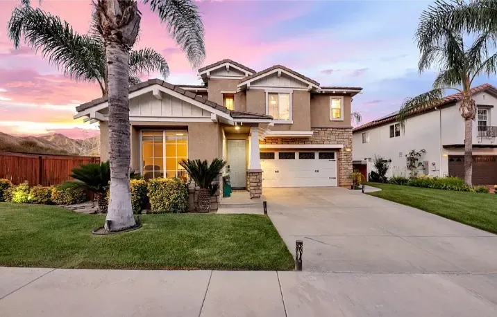 A luxury home featuring its driveway at dusk.