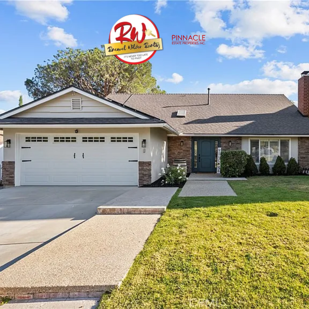 Single-story ranch home with brick accents and a white garage door, listed by Racquel Wilder Realty.