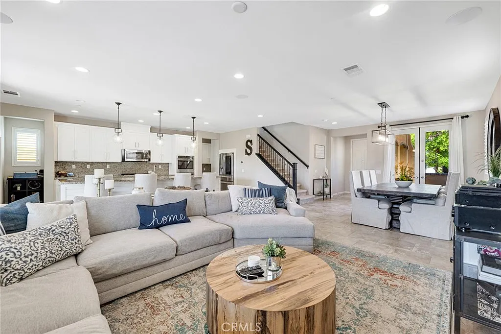 Spacious open-concept living area with sectional sofa, wood coffee table, and nearby kitchen | Realtor in Santa Clarita, CA