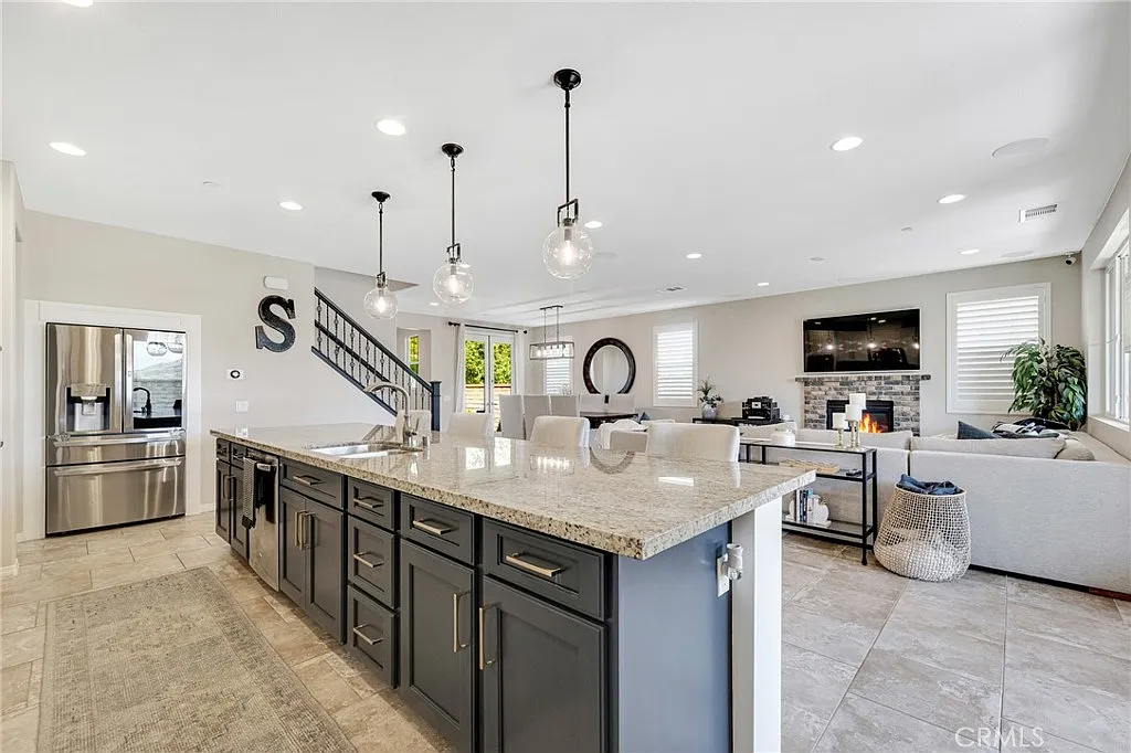 Spacious modern kitchen with dark gray island, light granite countertop, and pendant lights | Realtor in Santa Clarita, CA