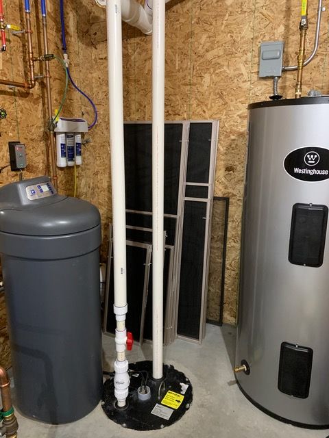 A water heater and a water softener are in a basement.
