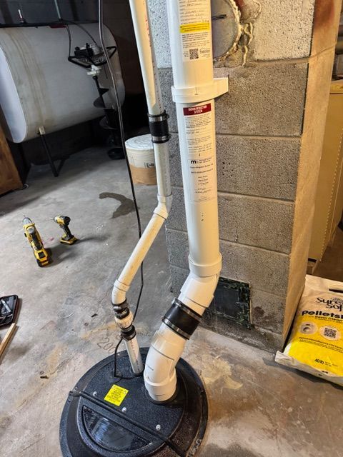 A drain pipe is being installed in a basement.