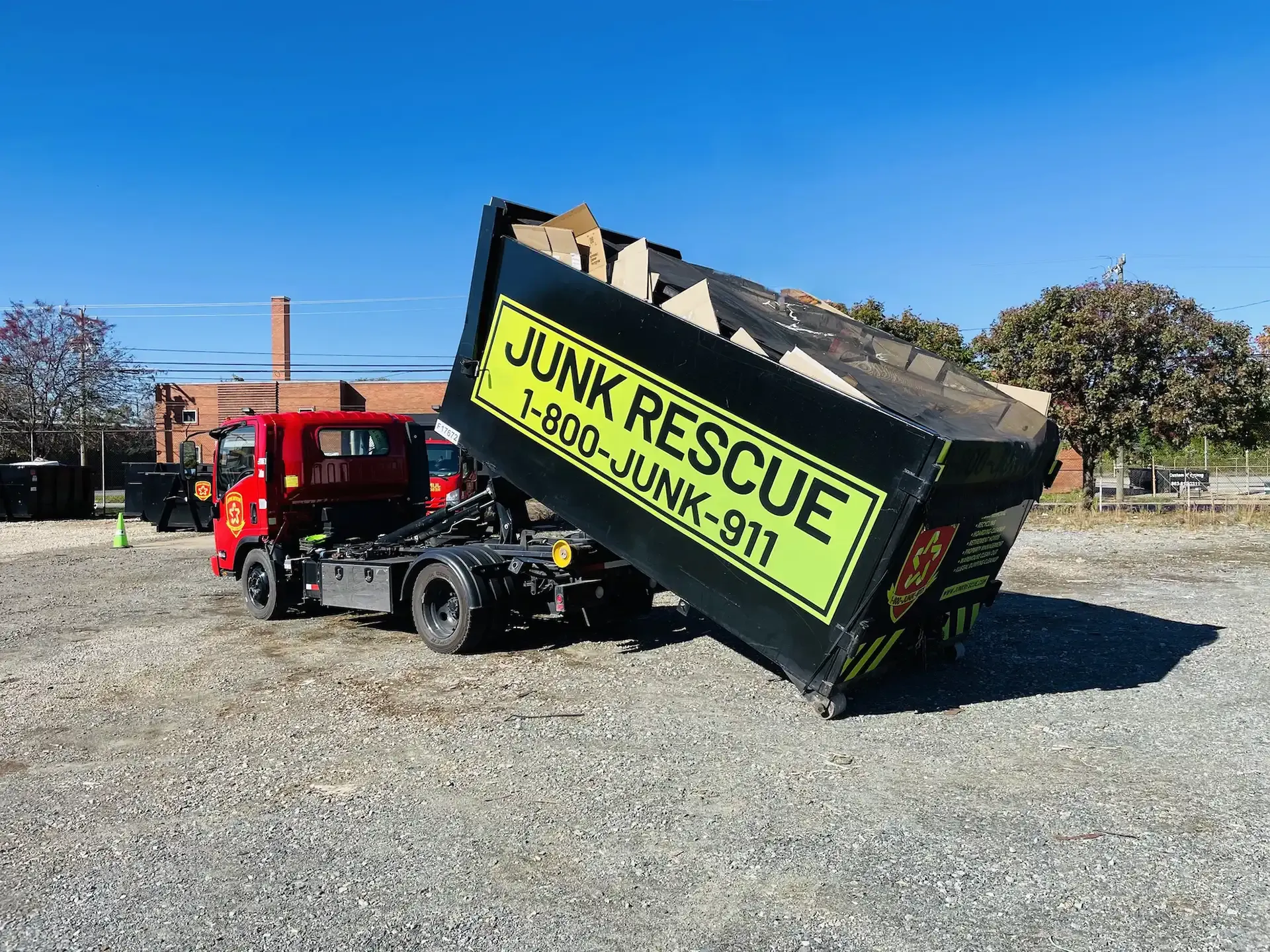 Red truck with black dumpster labeled 