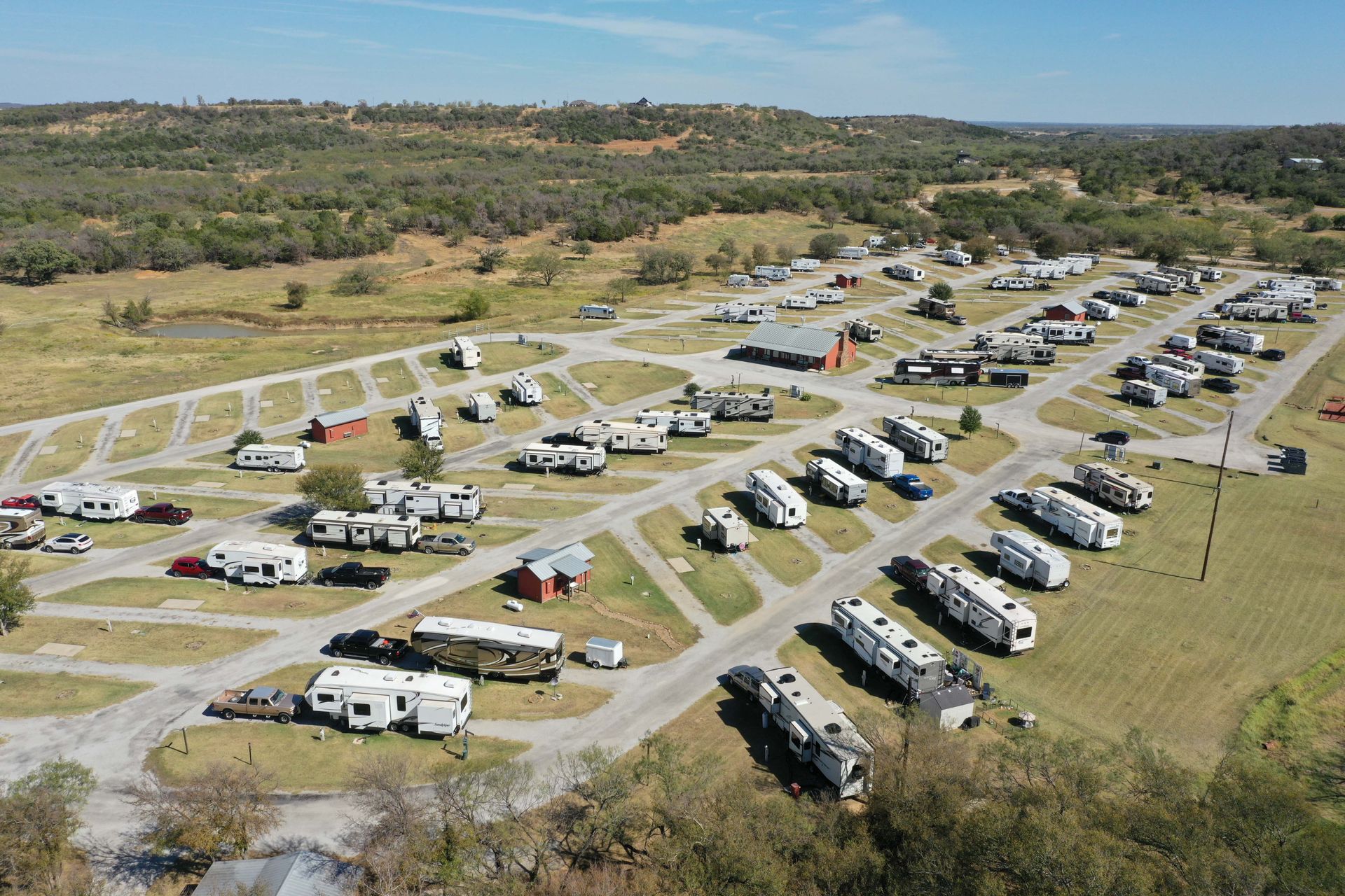 An aerial view of a rv park with lots of rvs parked in a field.