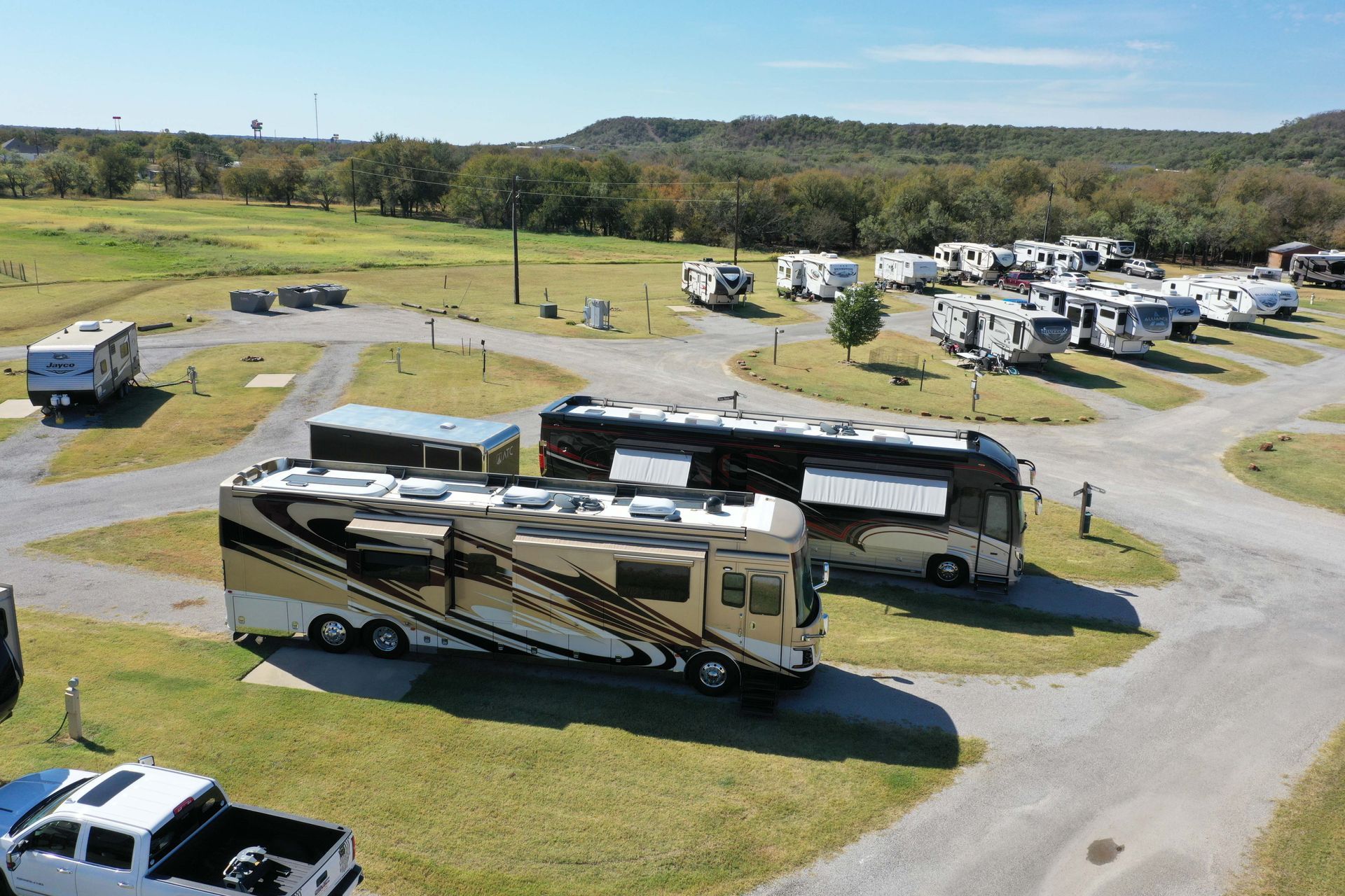 An aerial view of a campground with a lot of rv 's parked in the grass.