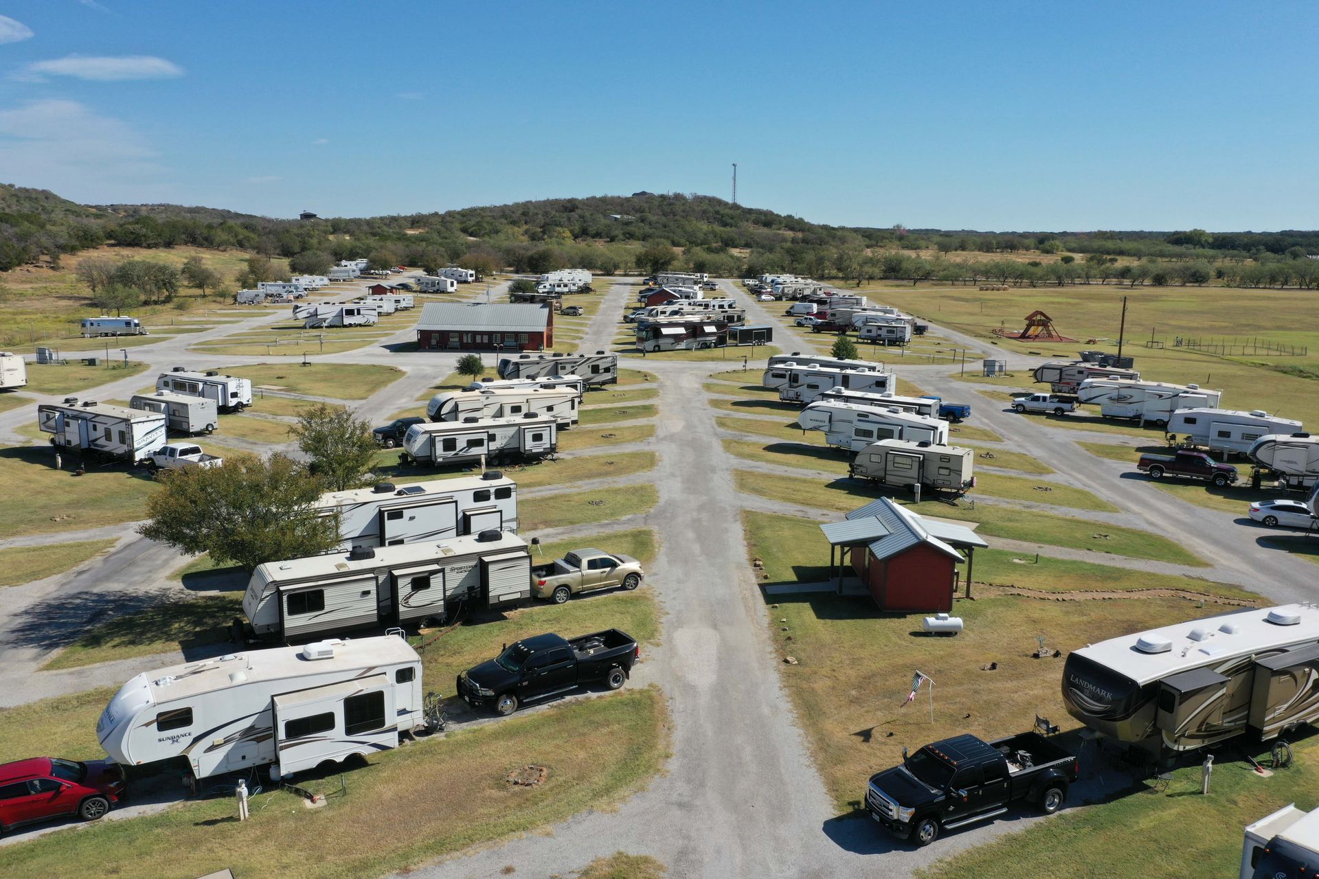 An aerial view of a campground filled with lots of rvs and trucks.
