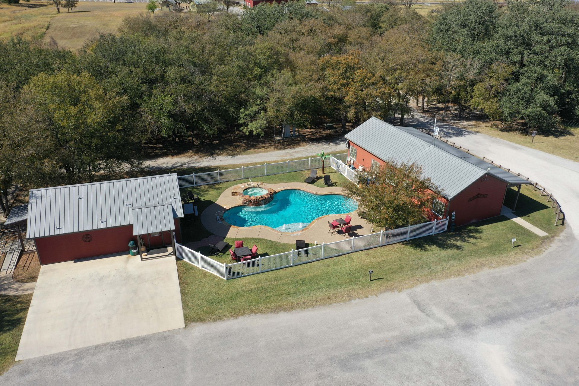 An aerial view of a house with a large pool in the backyard.