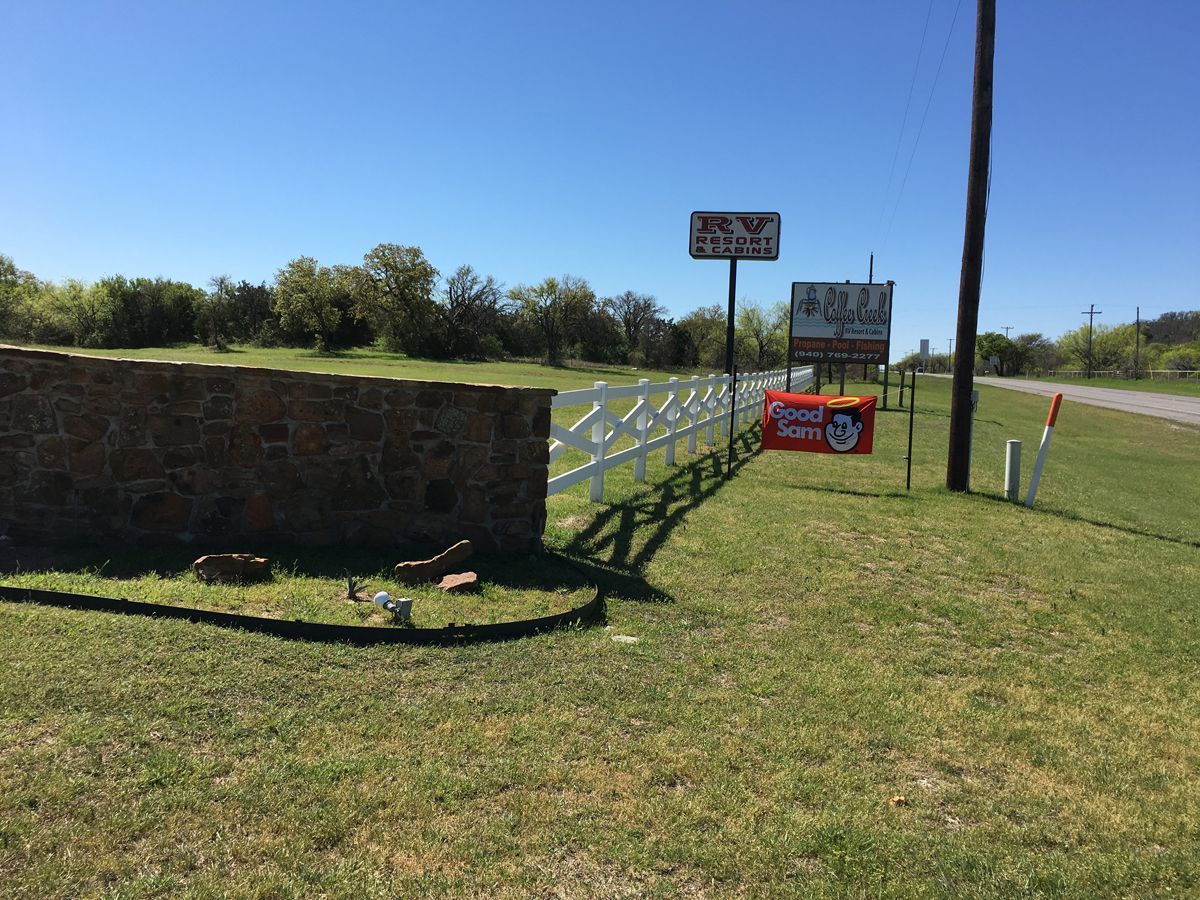 A stone wall is sitting in the middle of a grassy field.