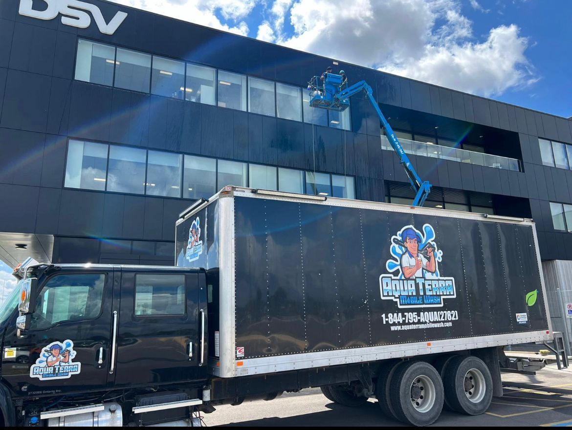 Black truck and lift cleaning windows on a black building.