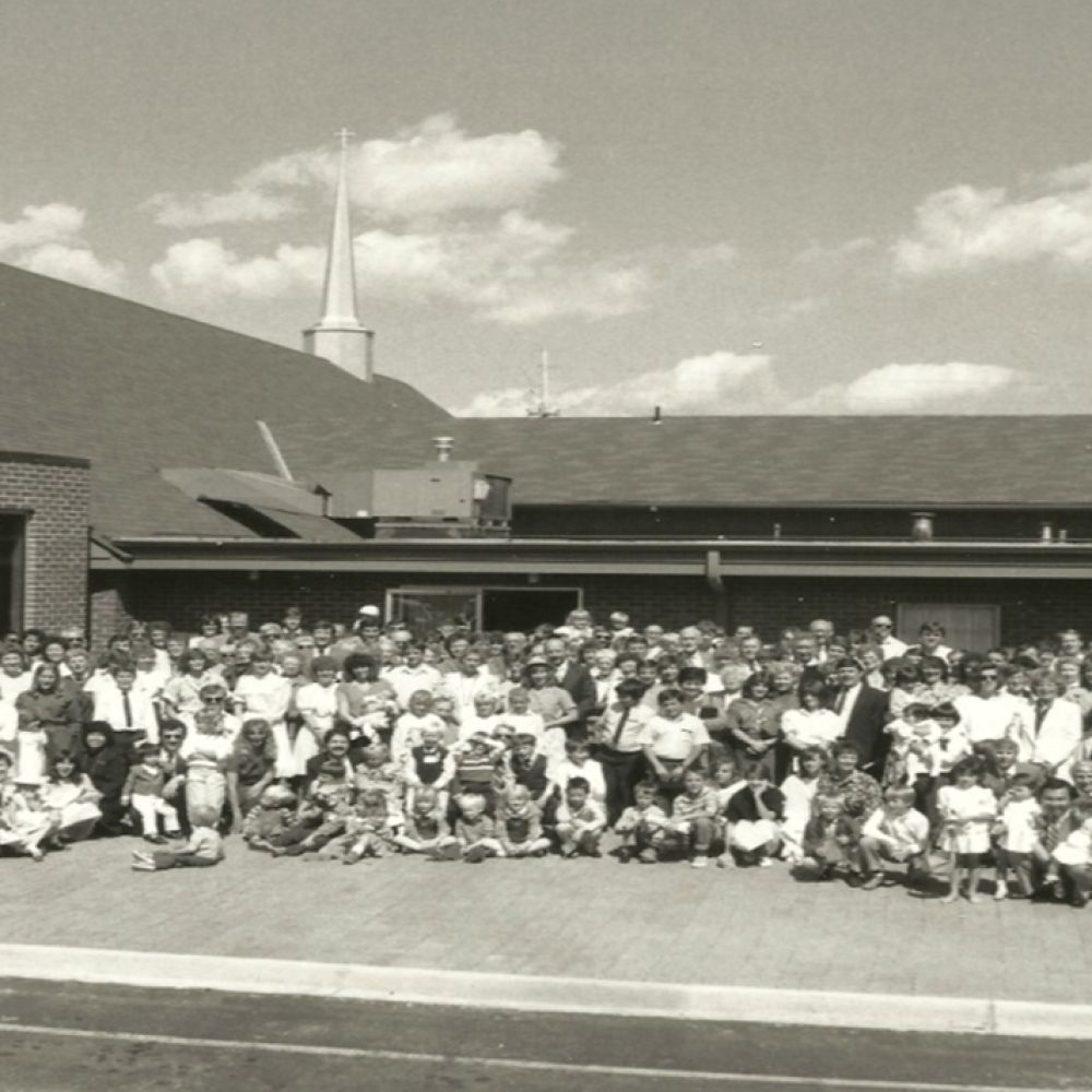 A large group of people are posing for a picture in front of a church