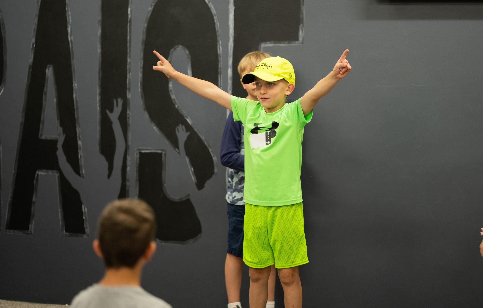 Two young boys are standing next to each other with their arms outstretched.