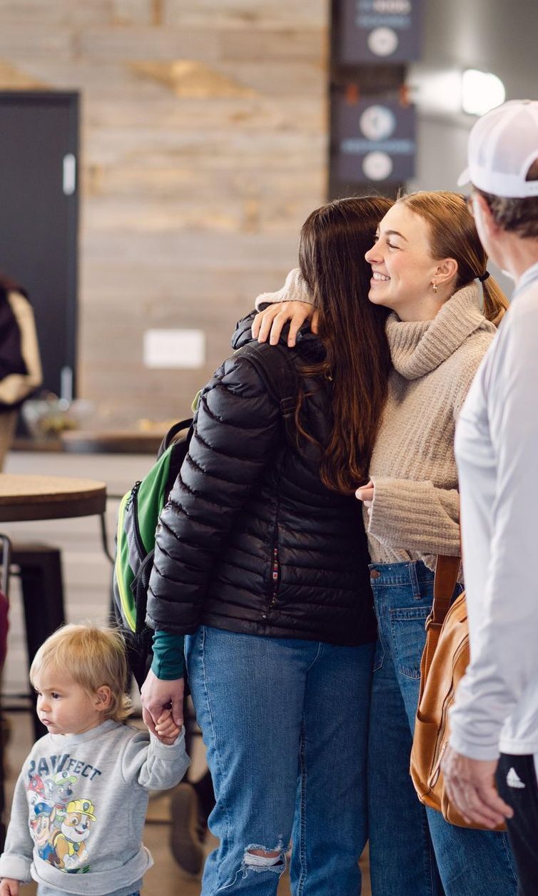 A group of people are hugging each other in a room.