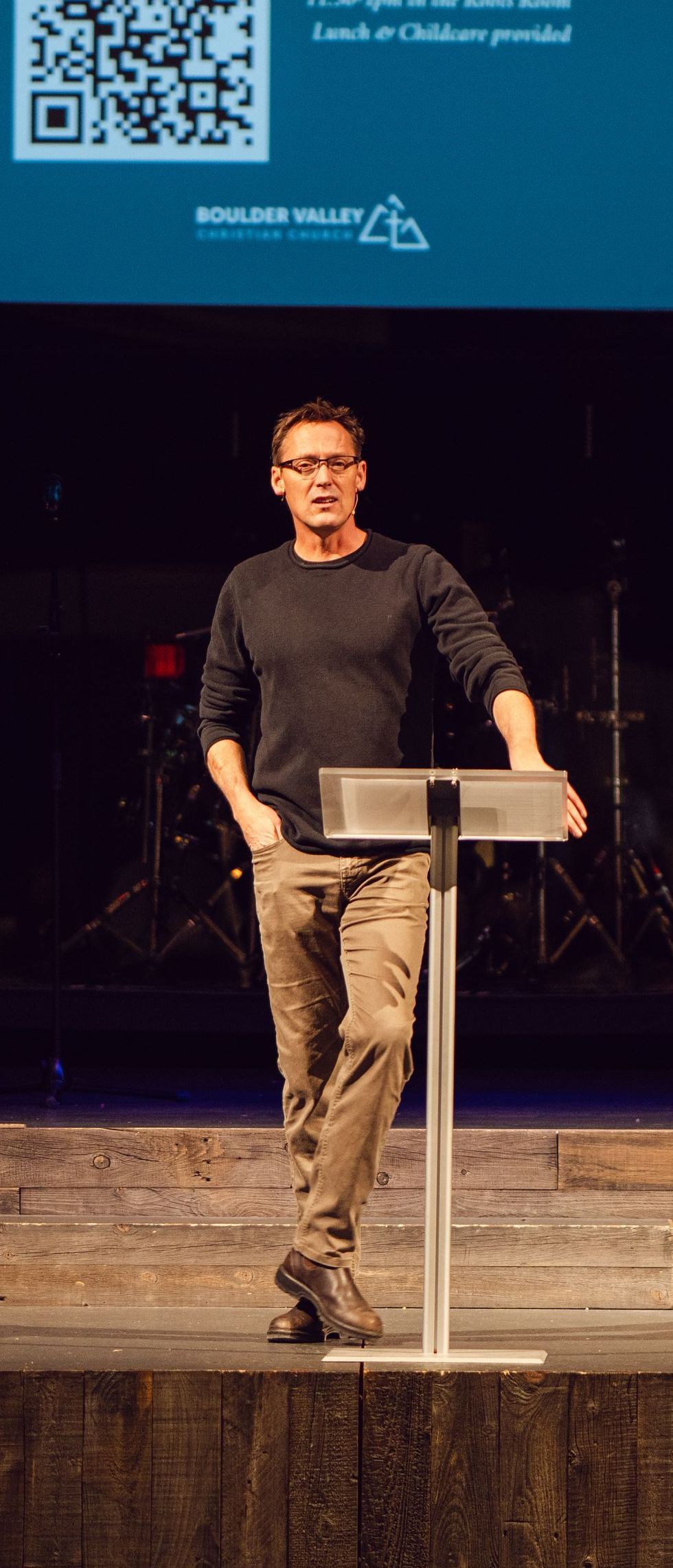 A man is standing at a podium on a stage.
