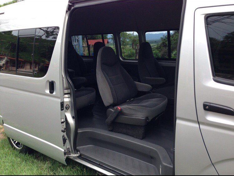 Silver passenger van, side door open revealing interior seating.