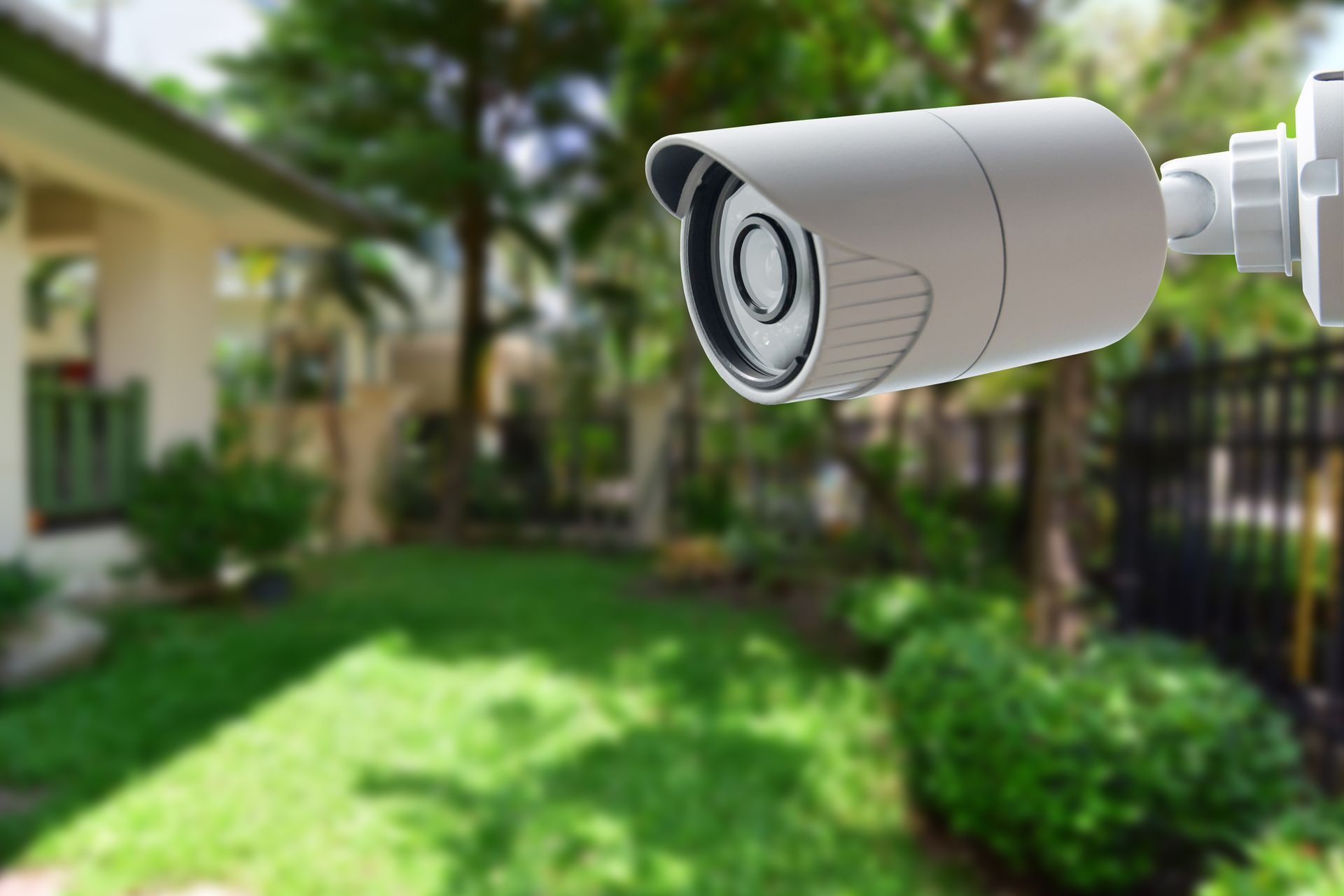 Security camera focused on a blurred residential backyard, suggesting surveillance of a home environment.