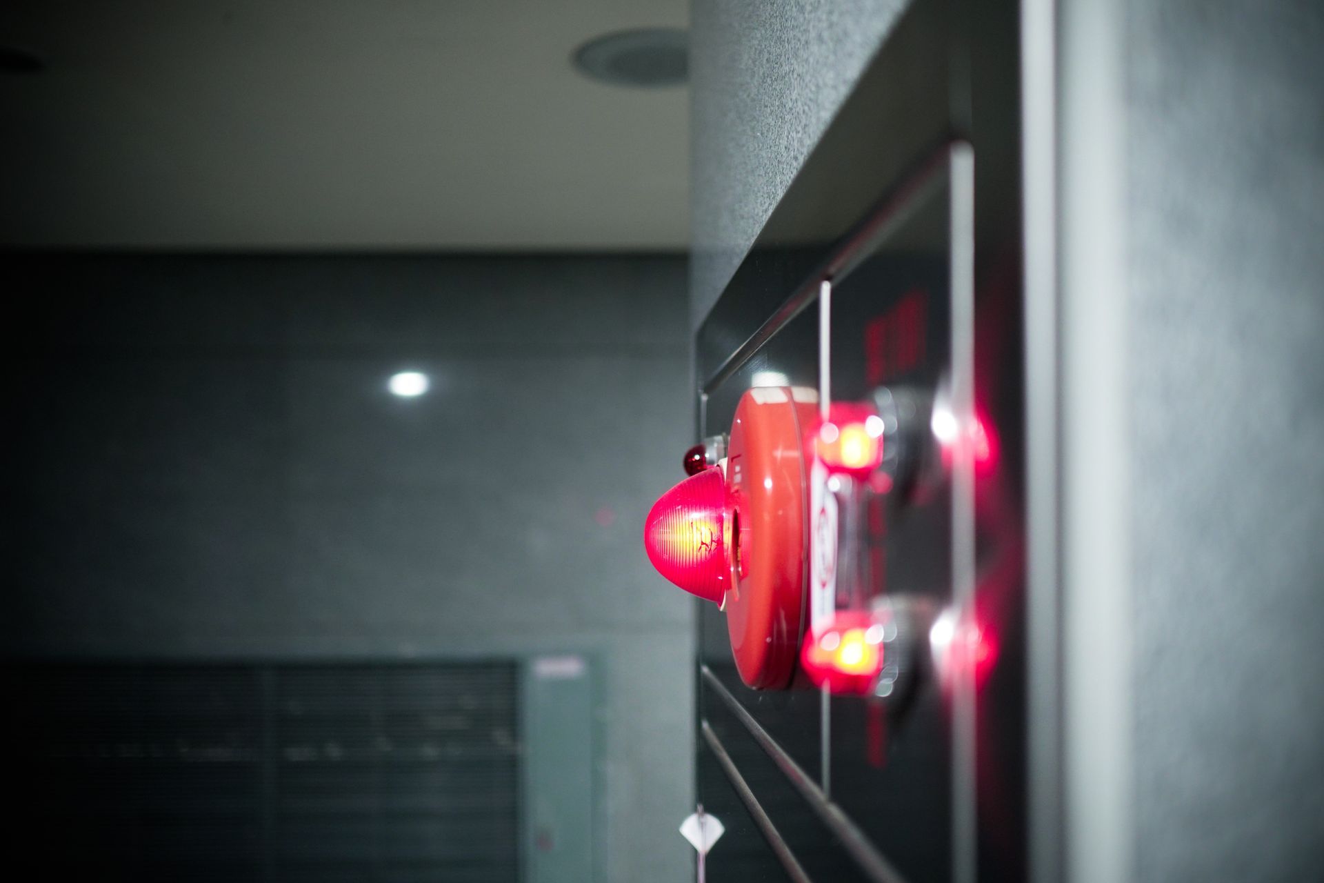 Several white and red fire alarm sensors arranged on top of a blueprint.