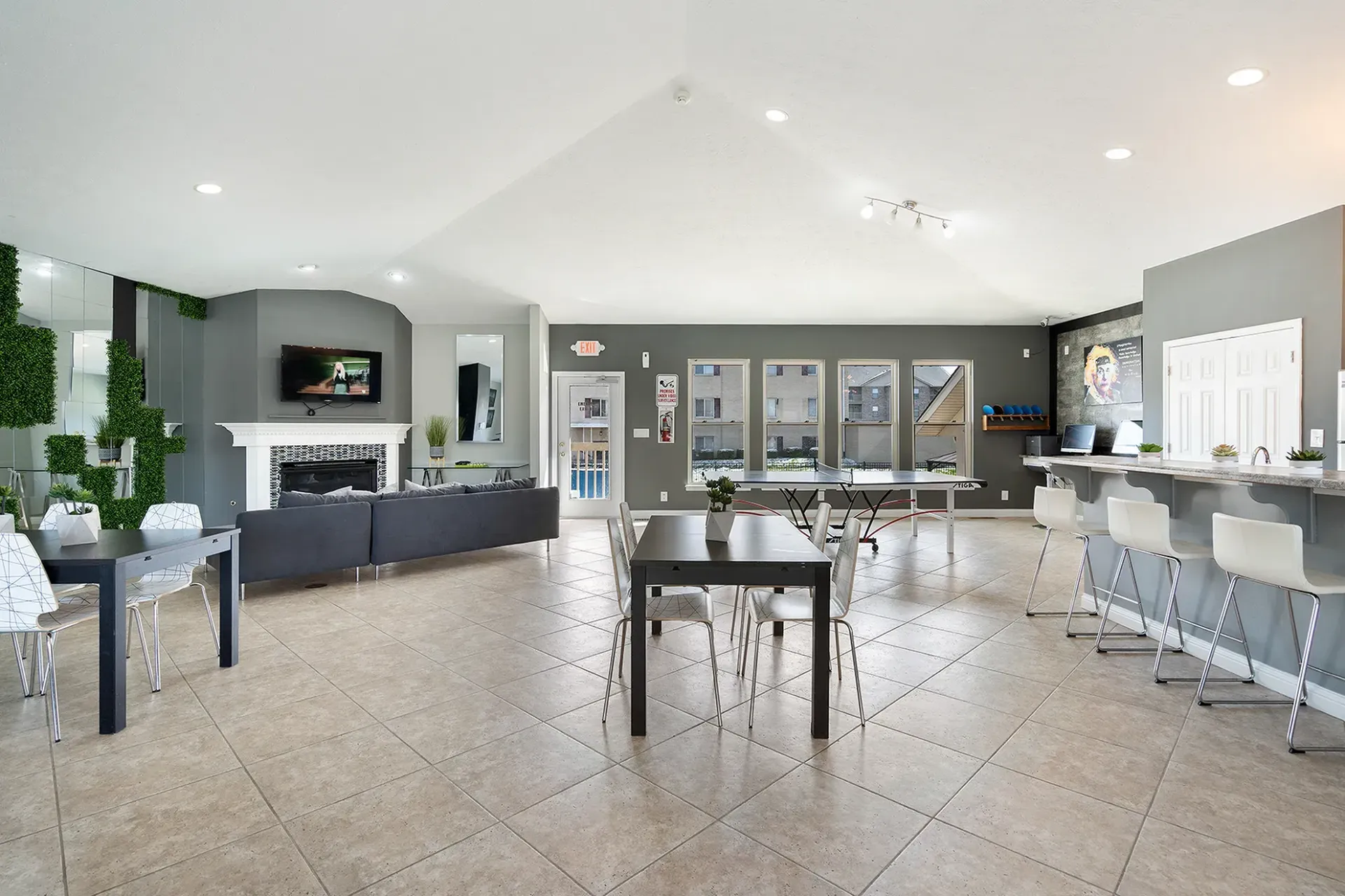 Photo of clubhouse with tables, chairs, couch, and television