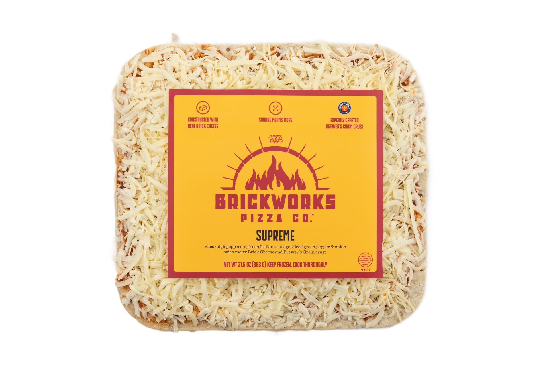 Square white pizza base with yellow label, topped with shredded cheese on a plain background