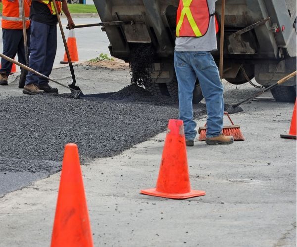 A group of construction workers are working on a road