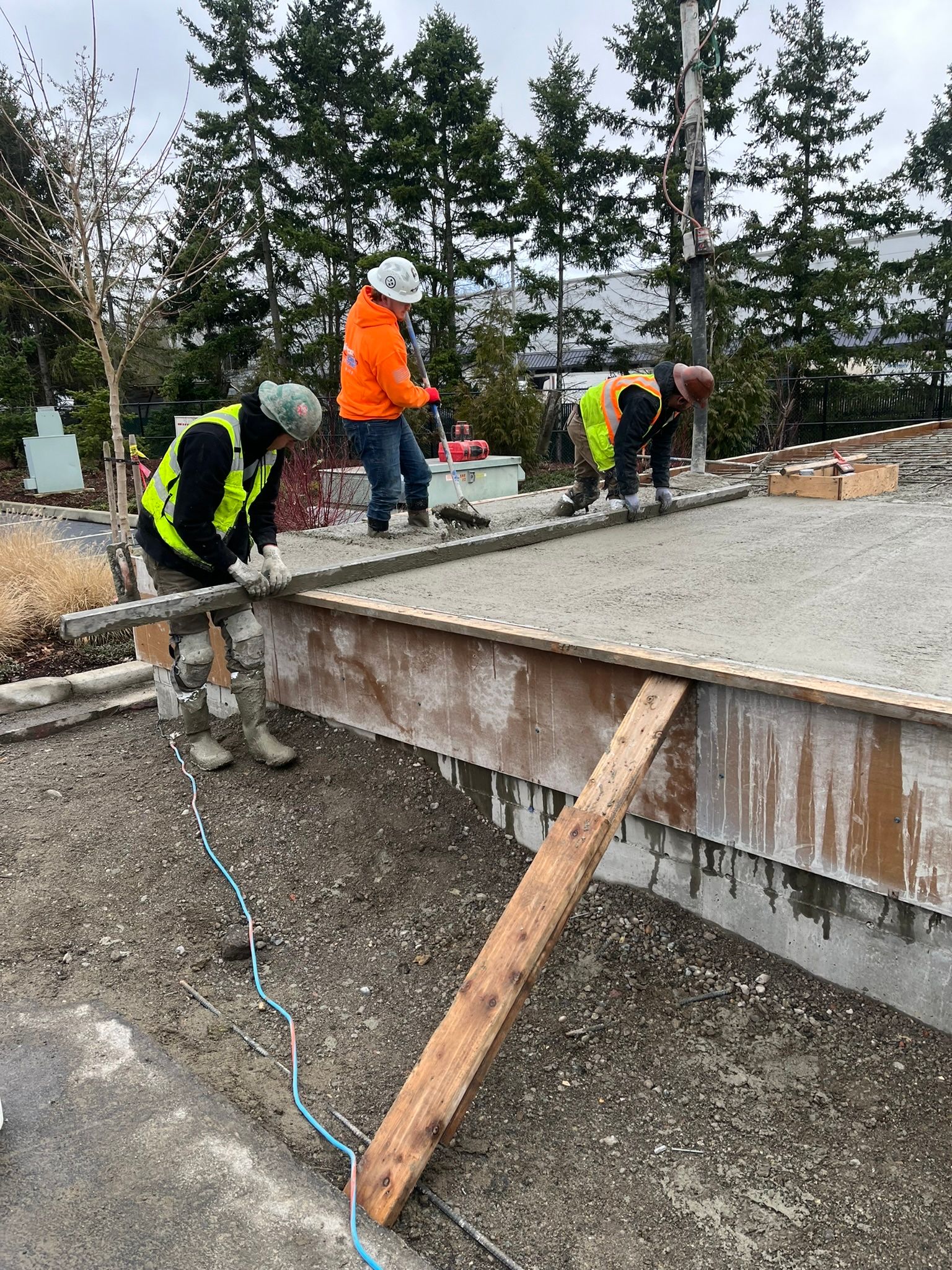 A group of construction workers are working on a concrete floor.