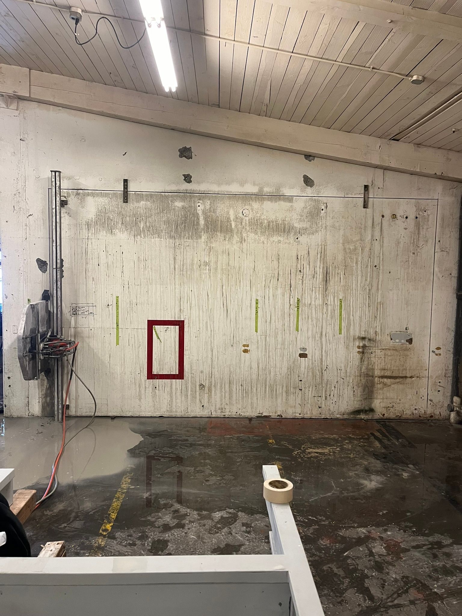 An empty room with a white wall and a red square on it.