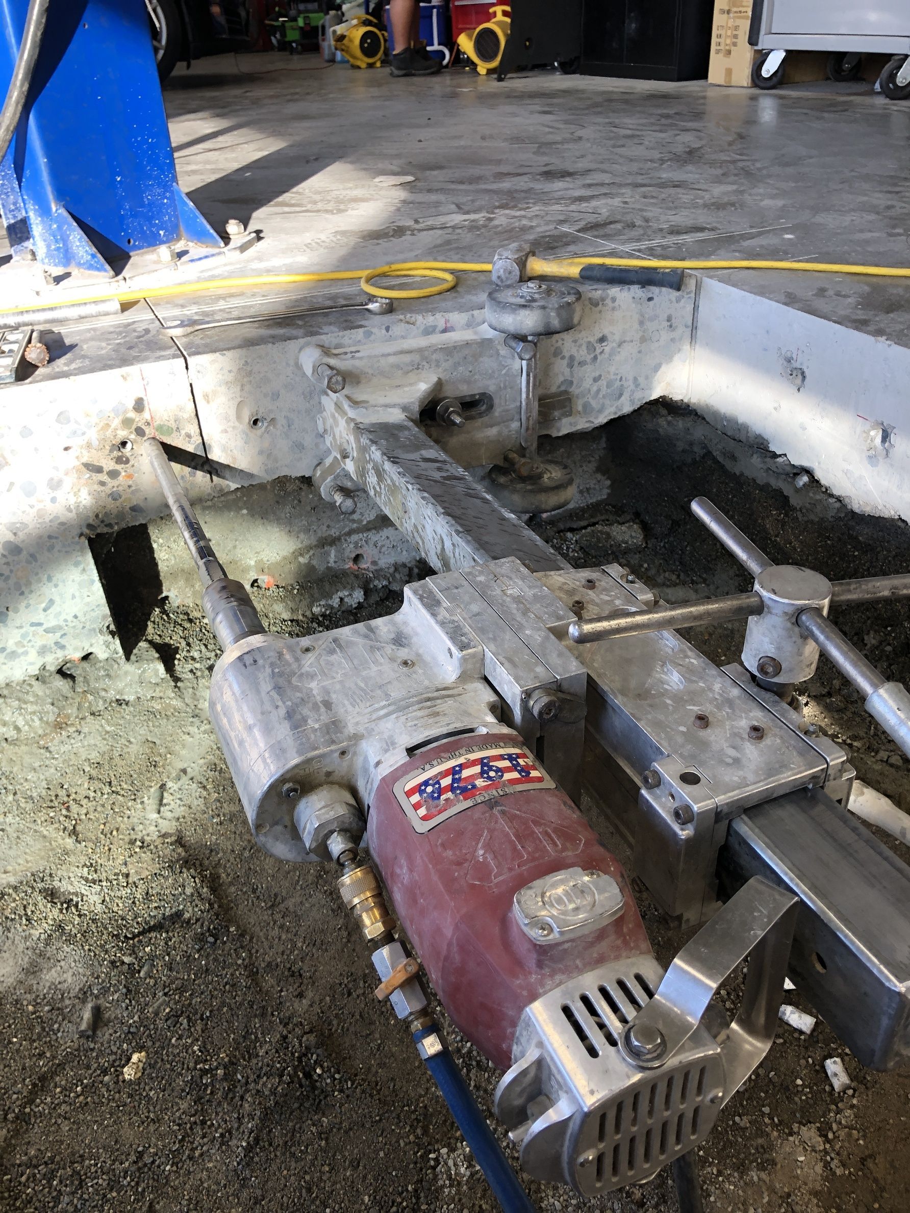 A concrete cutting machine is sitting on the ground in a garage.