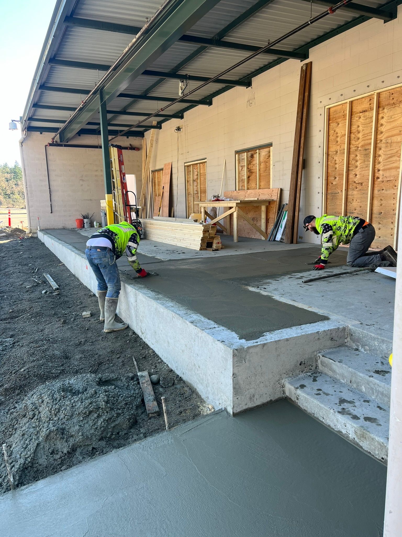 A group of construction workers are working on a concrete floor.