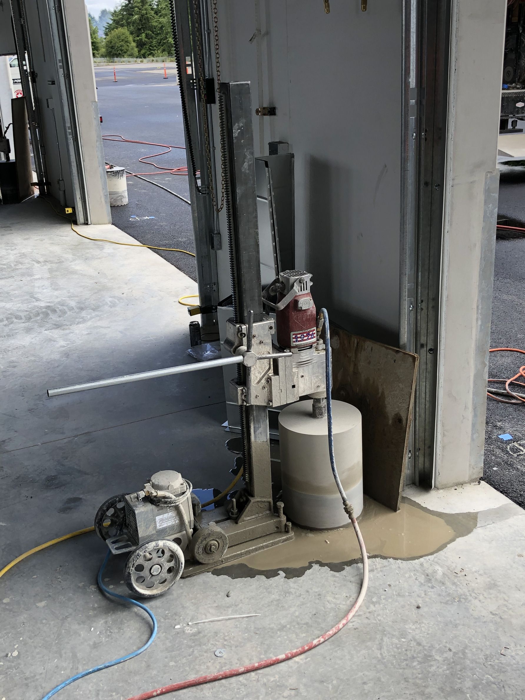 A machine is cutting a hole in a concrete wall.