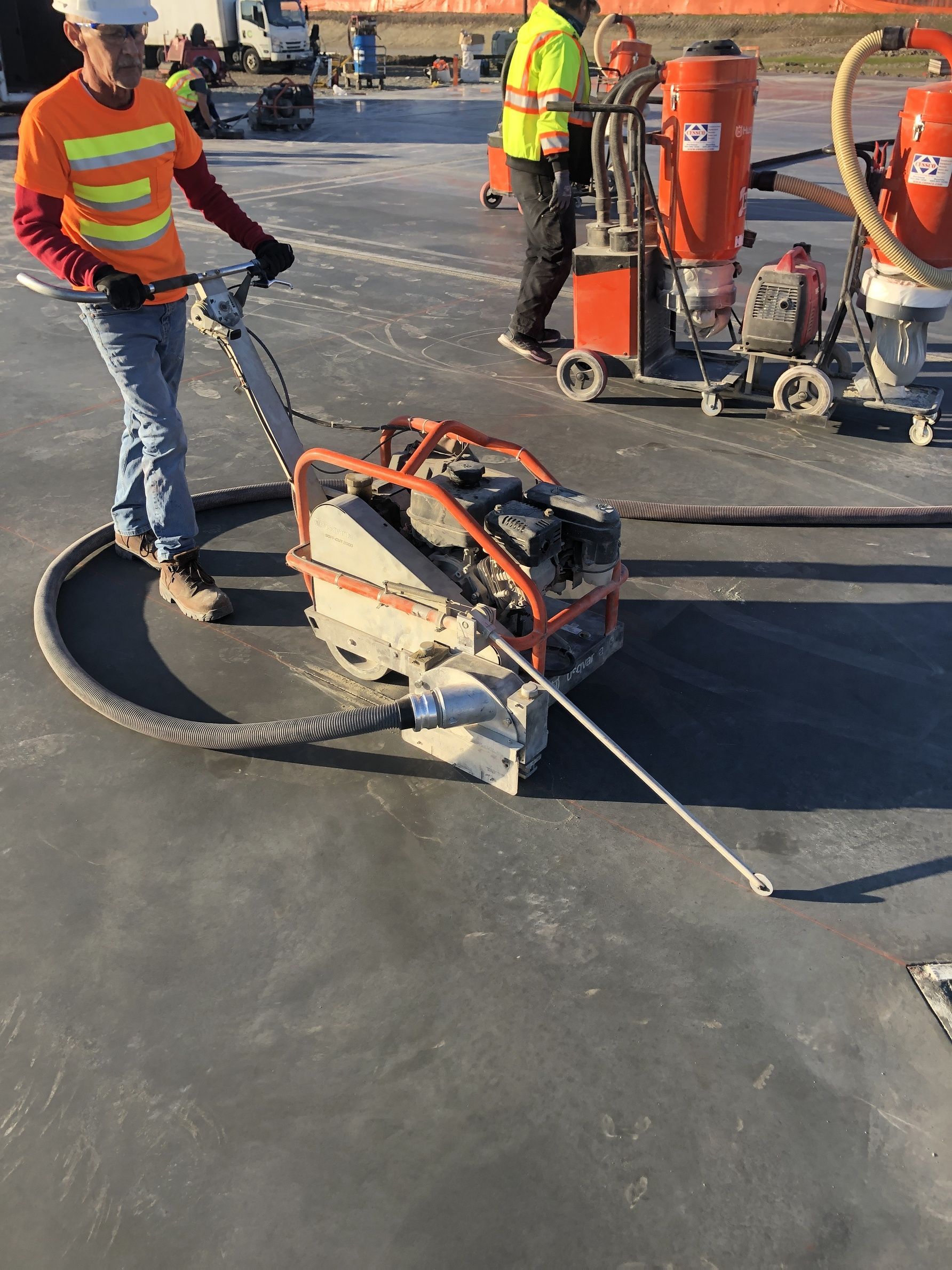A construction worker is using a machine to cut concrete