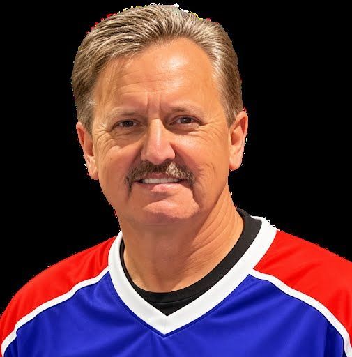 Smiling man in a red, blue, and white hockey jersey against a black background