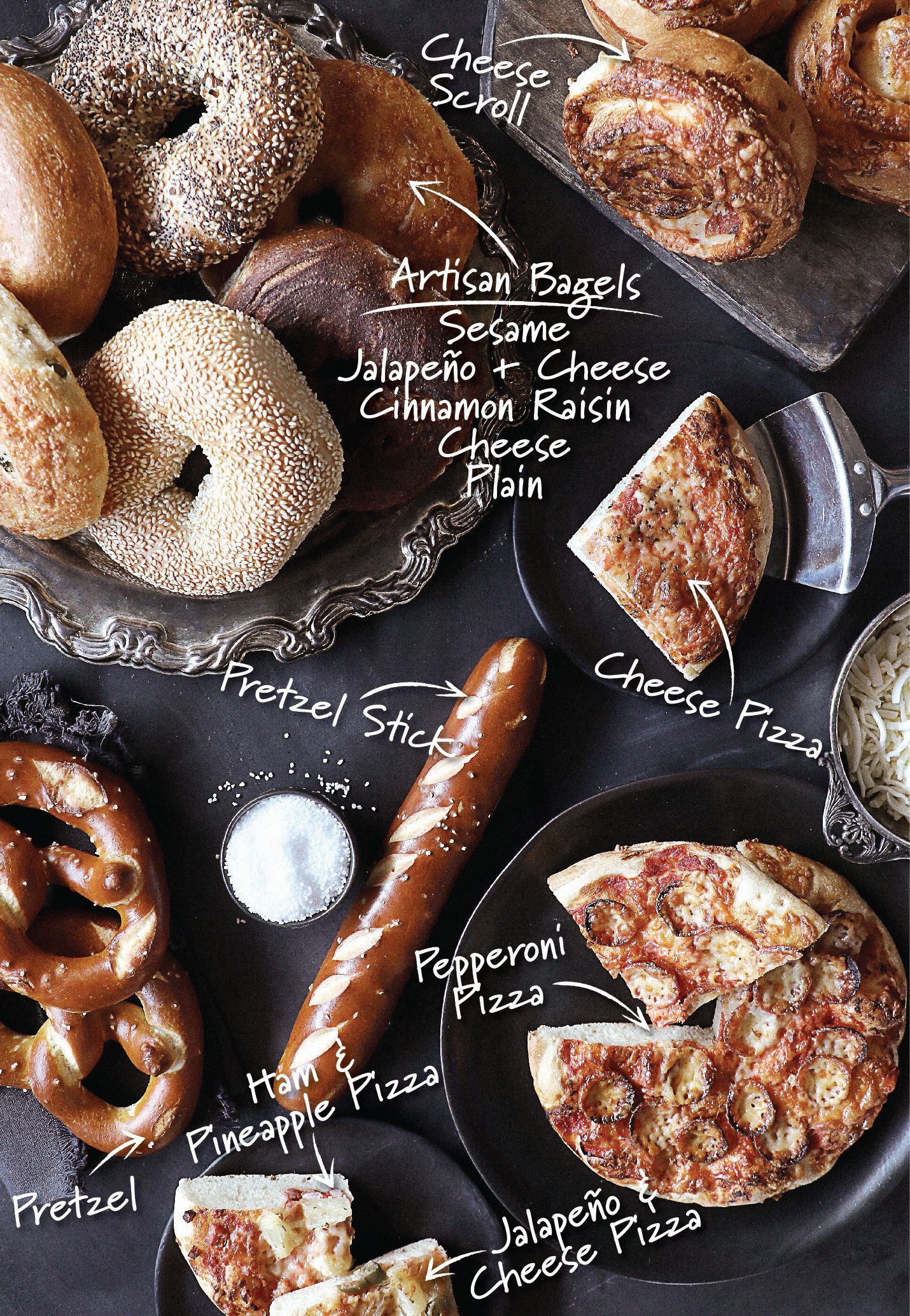 A table topped with plates of food including pretzels and pizza