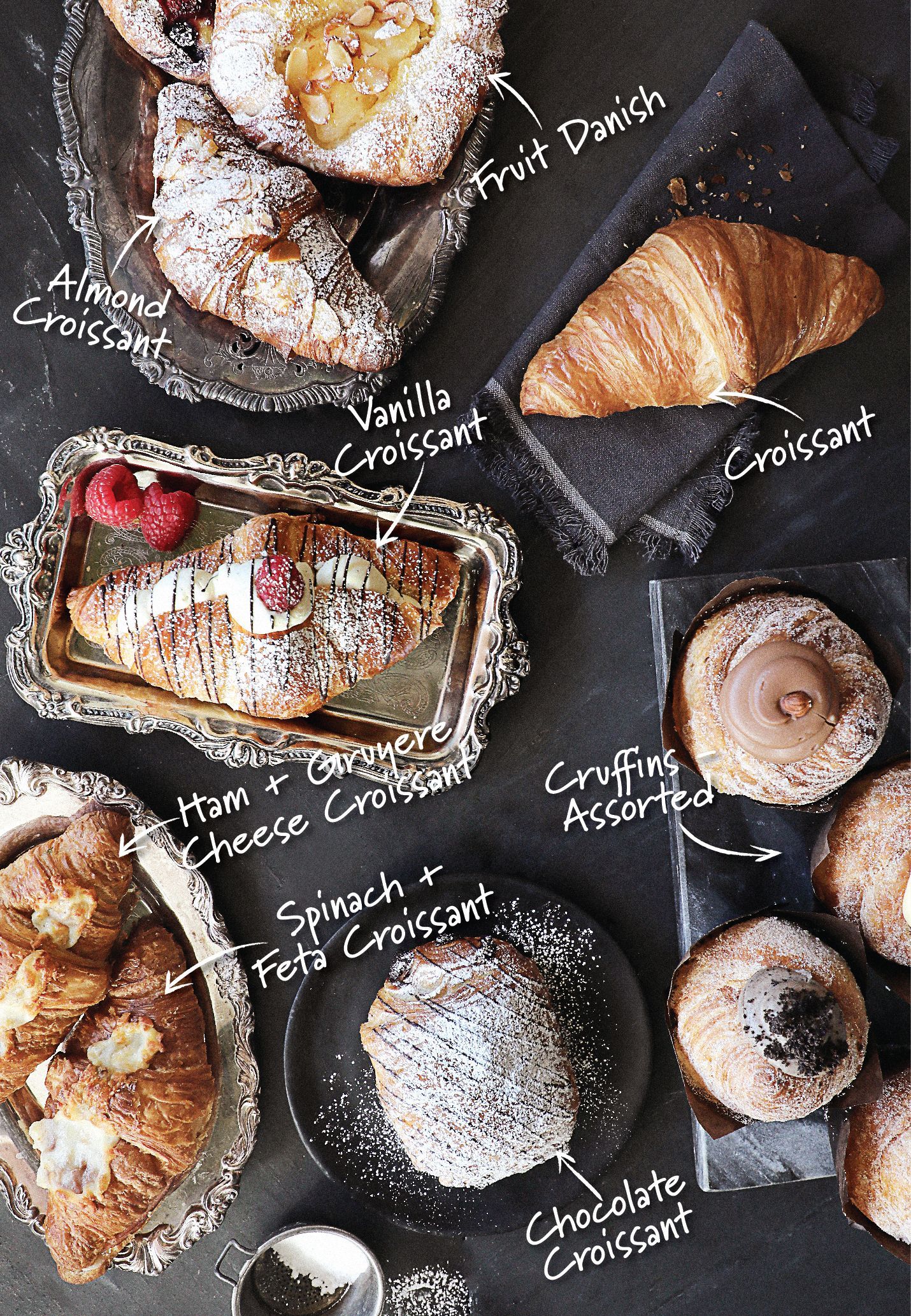 A variety of pastries and croissants are on a table.