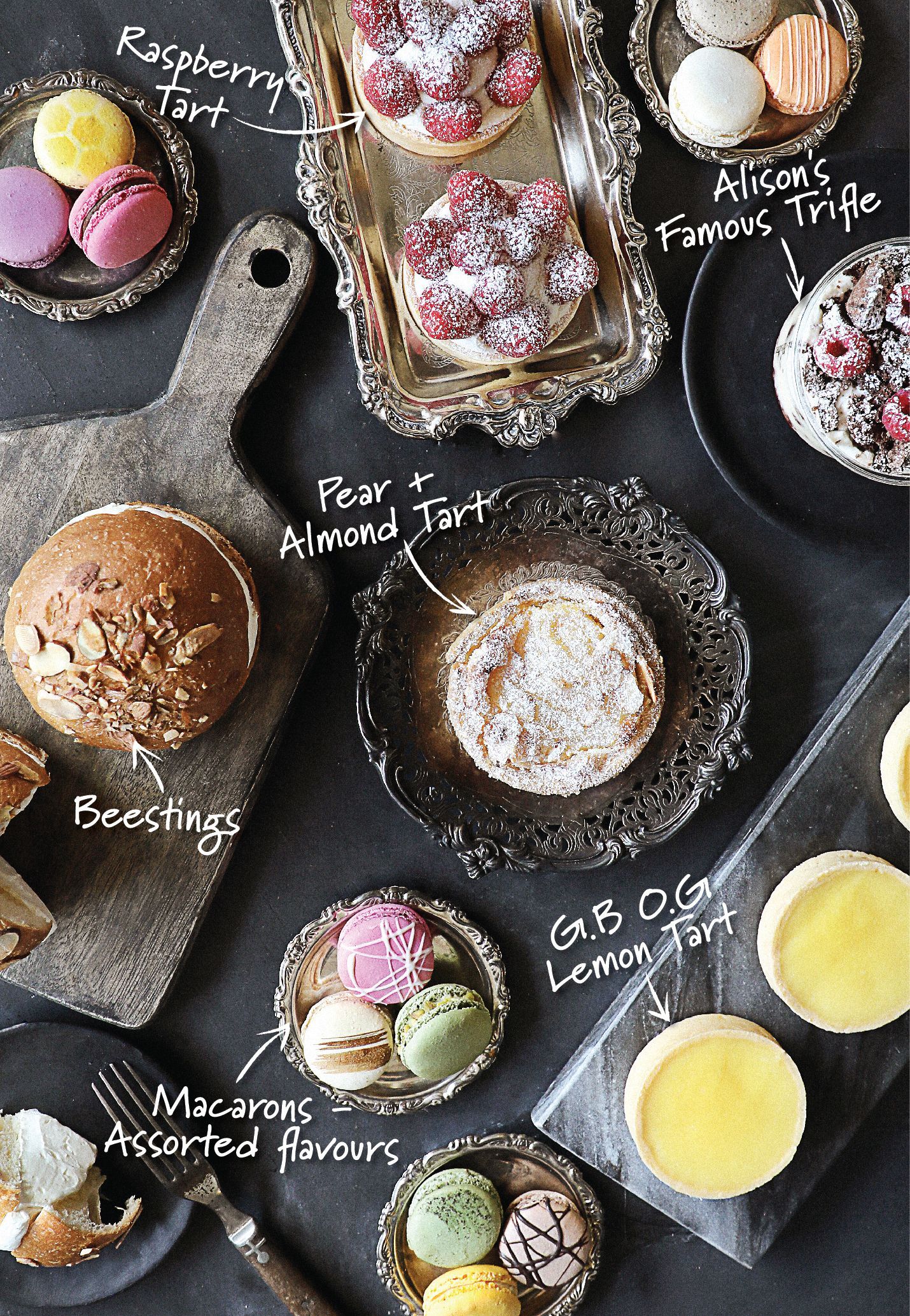 A table topped with a variety of desserts including a raspberry tart