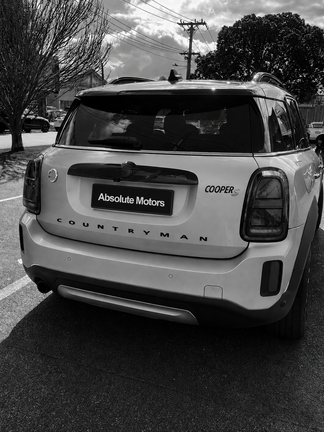 Black-and-white rear view of a white Lincoln Corsair SUV parked outdoors in a lot.