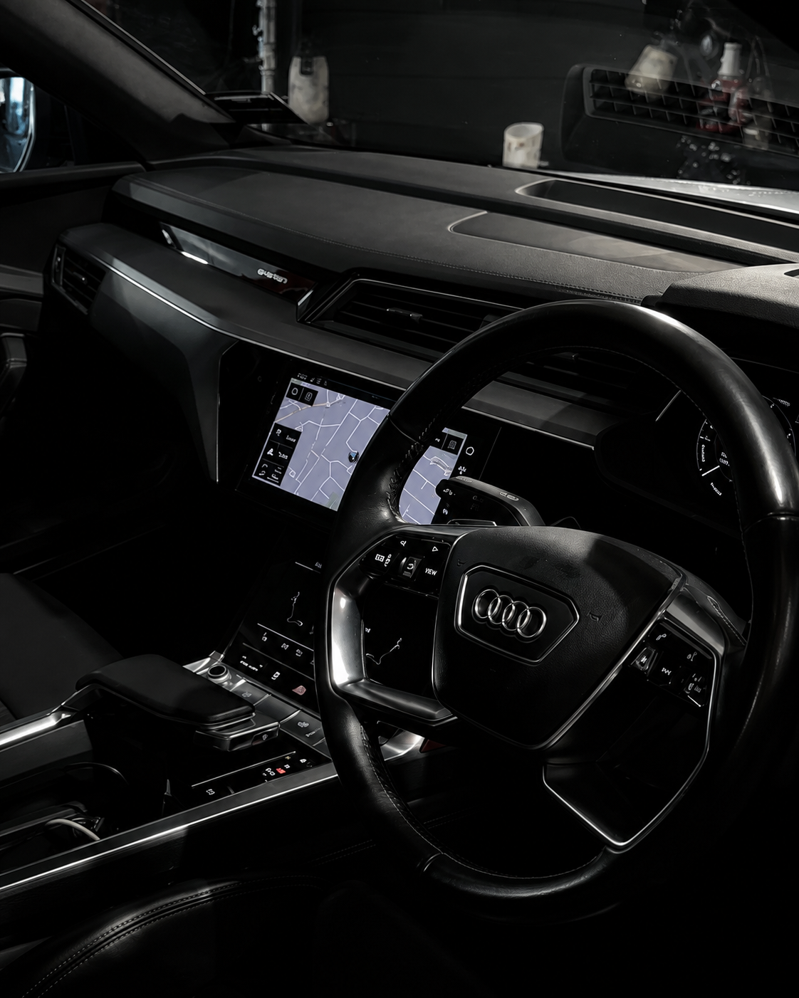 Dark car interior with a Toyota steering wheel and illuminated center display at night