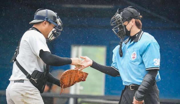 Baseball player sliding into home plate, catcher in front. Blue and gold uniforms, action shot.