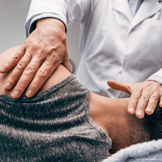 A healthcare provider adjusting a patient’s neck and shoulders during a chiropractic session.