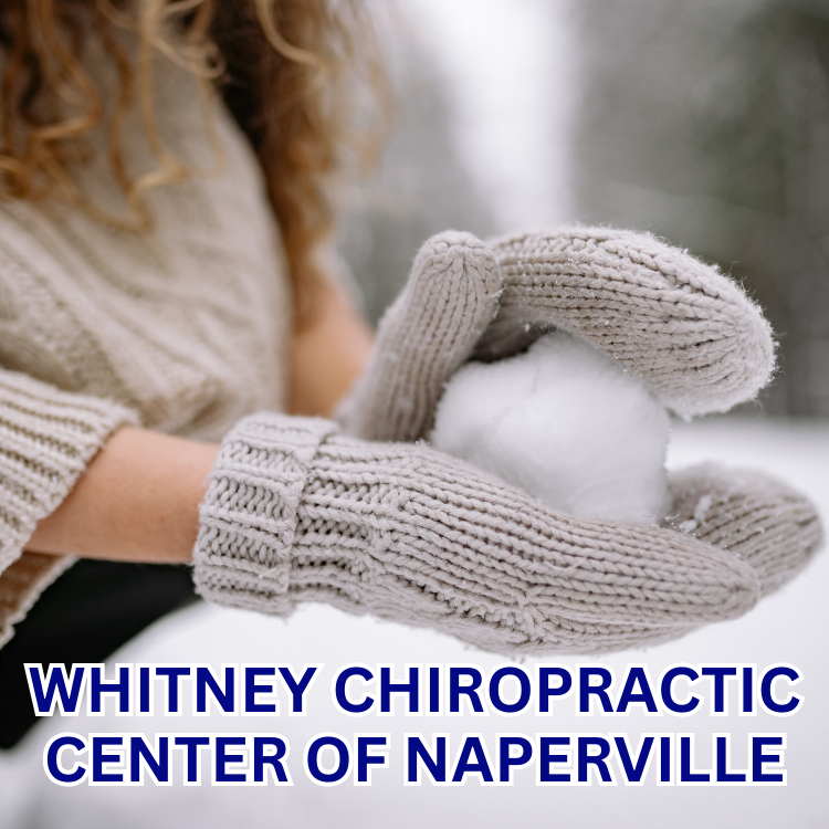 Person in knit mittens holding a snowball in a snowy outdoor setting. Whitney Chiropractic Center logo.