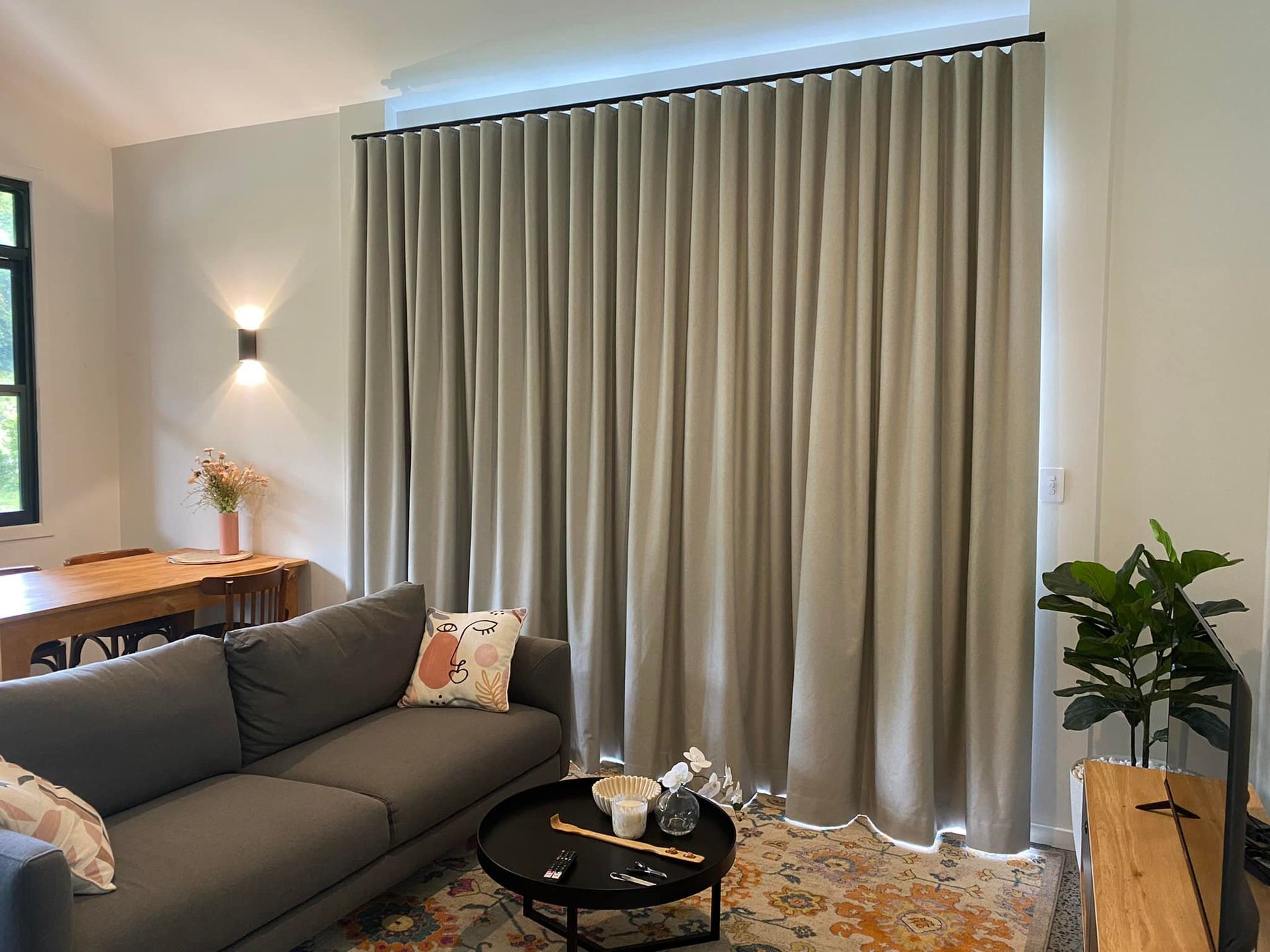 Curtains Are Hanging on a Window in a Living Room With a Couch, Tv, and Coffee Table— Lismore Curtains & Blinds In Lismore, NSW