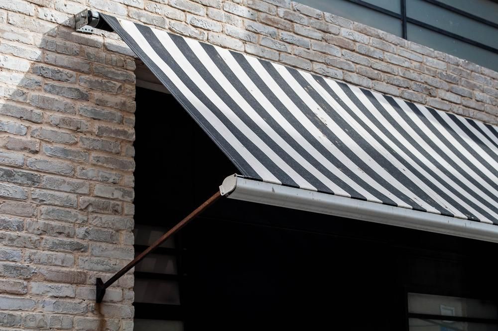 A Black and White Striped Awning — Lismore Curtains & Blinds In Lismore, NSW