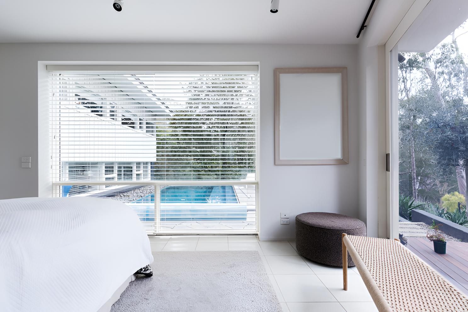 A Bedroom With a Sliding Glass Door Leading to a Swimming Pool Outside— Lismore Curtains & Blinds In Byron Bay, NSW
