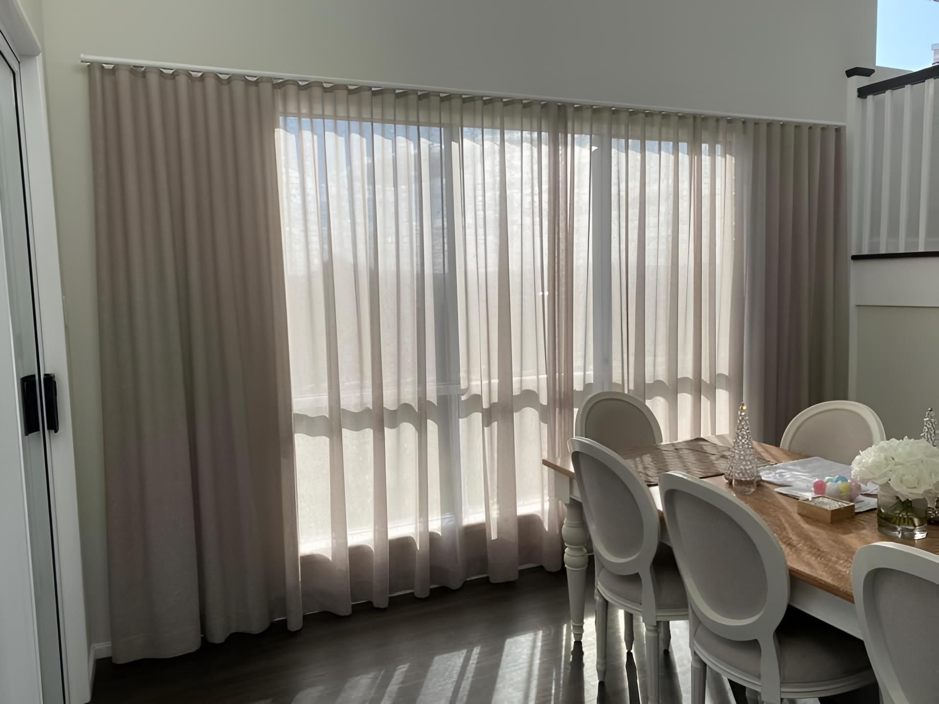 A Dining Room With a Table and Chairs and Curtains on the Windows — Lismore Curtains & Blinds In Byron Bay, NSW